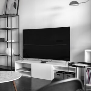 flat screen television on top of white wooden low-line TV stand